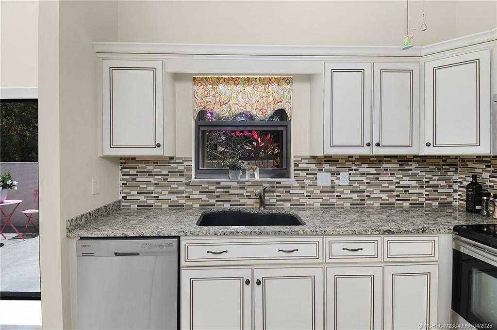 3401 Southeast Martinique Trace, Unit 101 Stuart, FL 34997 - Photo 40 of 51 a kitchen with granite countertop a sink stove and cabinets