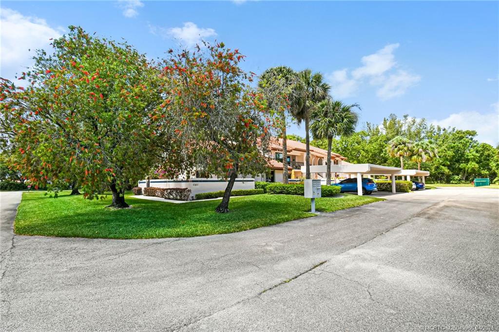 3401 Southeast Martinique Trace, Unit 101 Stuart, FL 34997 - Photo 4 of 51 a front view of a house with a yard and trees