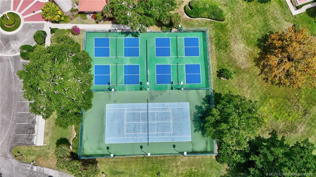 3401 Southeast Martinique Trace, Unit 101 Stuart, FL 34997 - Photo 47 of 51 a view of a brick house with plants and large trees
