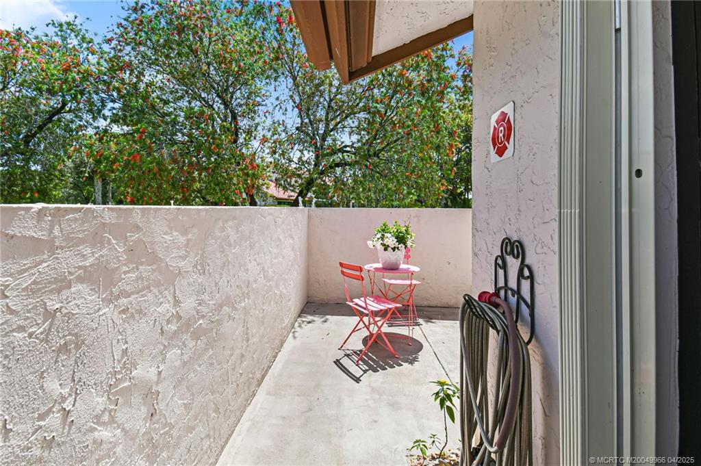 3401 Southeast Martinique Trace, Unit 101 Stuart, FL 34997 - Photo 8 of 51 a view of a patio with table and chairs and potted plants