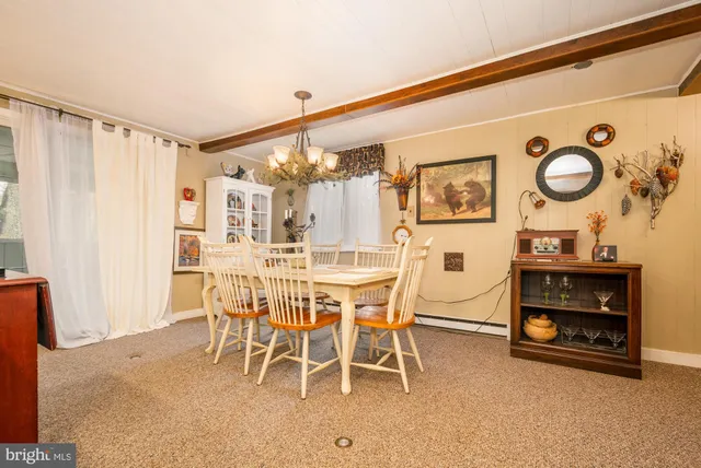 a living room with furniture a large window and stainless steel appliances