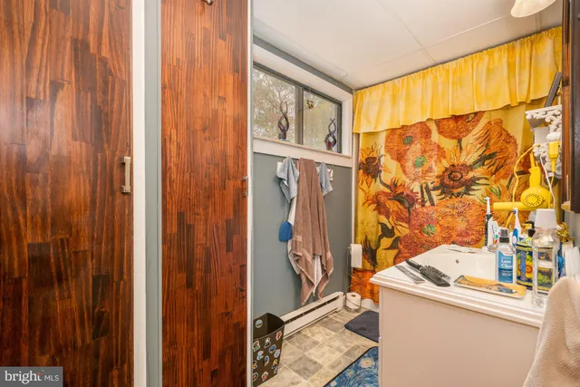 a bedroom with a bed a dresser and a chandelier