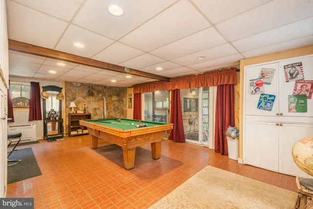 a room with pool table and windows