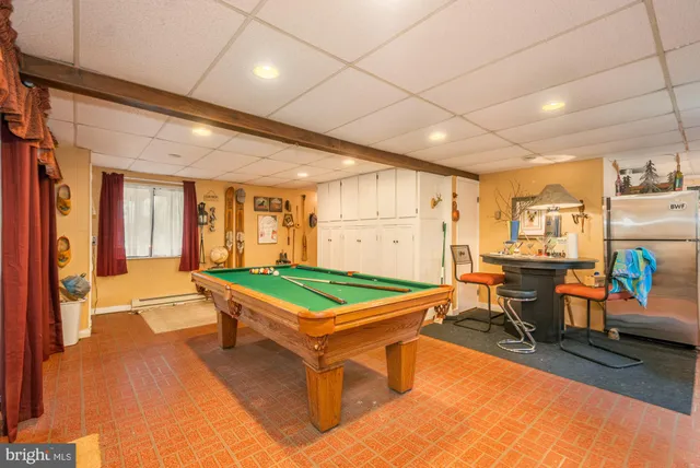 a room with pool table and windows