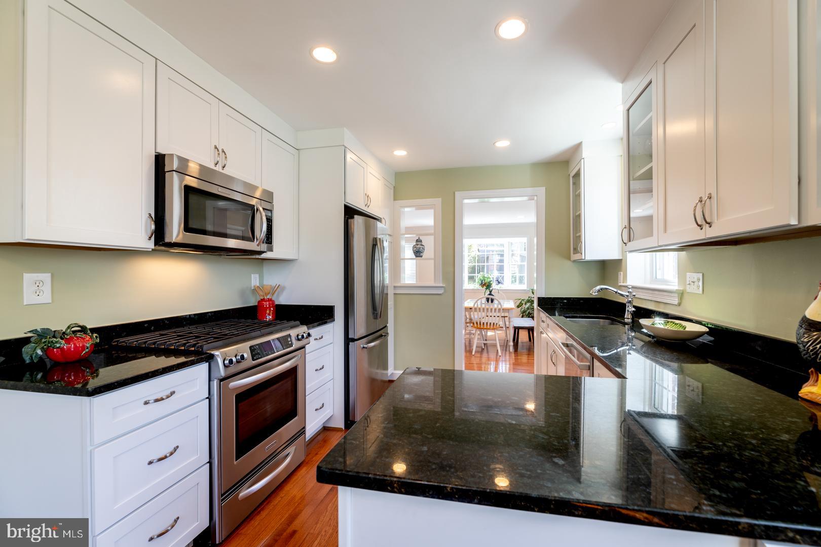 10009 Raynor Road Silver Spring, MD 20901 - Photo 12 of 34 a kitchen with stainless steel appliances granite countertop a stove a sink and a microwave