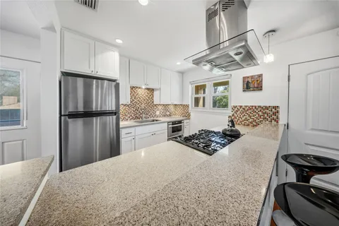 a kitchen with stainless steel appliances granite countertop a refrigerator stove microwave and sink