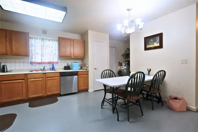 a kitchen with a dining table chairs stainless steel appliances and cabinets
