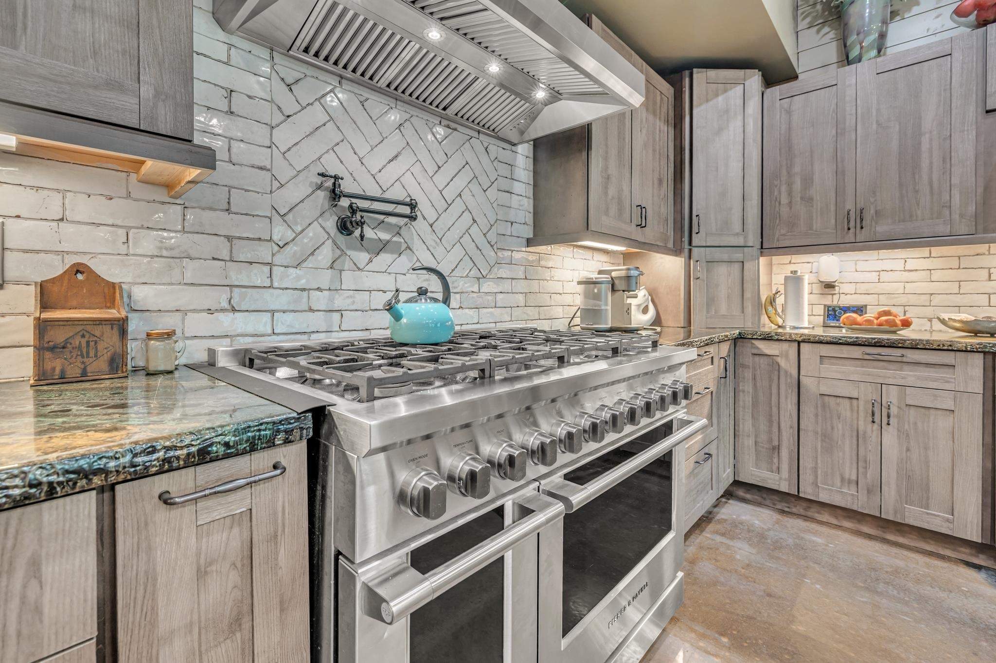 350 Hamilton Road Springville, TN 38256 - Photo 13 of 40 Gourmet kitchen featuring a stainless steel gas range with double ovens, a herringbone brick-pattern backsplash, a stainless steel range hood, and wood cabinetry with under-cabinet lighting