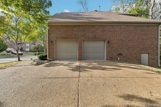 an empty room with wooden floor chandelier and windows