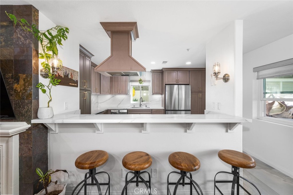 1516 Pacific Coast Highway, Unit 101 Huntington Beach, CA 92648 - Photo 11 of 58 a kitchen with stainless steel appliances a dining table chairs sink and cabinets