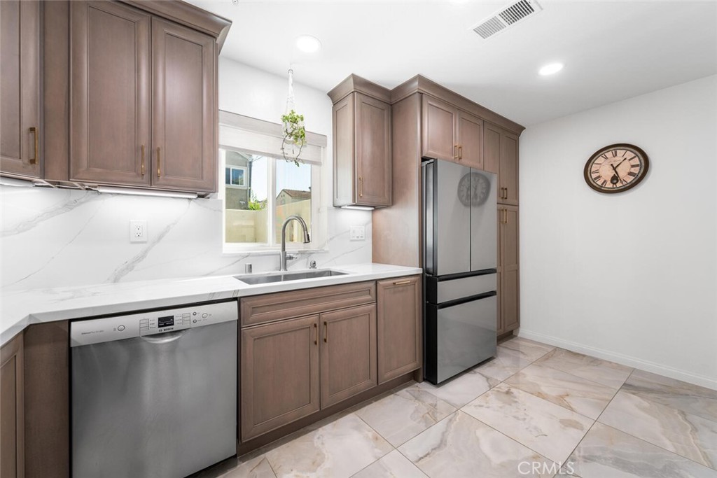 1516 Pacific Coast Highway, Unit 101 Huntington Beach, CA 92648 - Photo 18 of 58 a kitchen with stainless steel appliances granite countertop a refrigerator and a sink