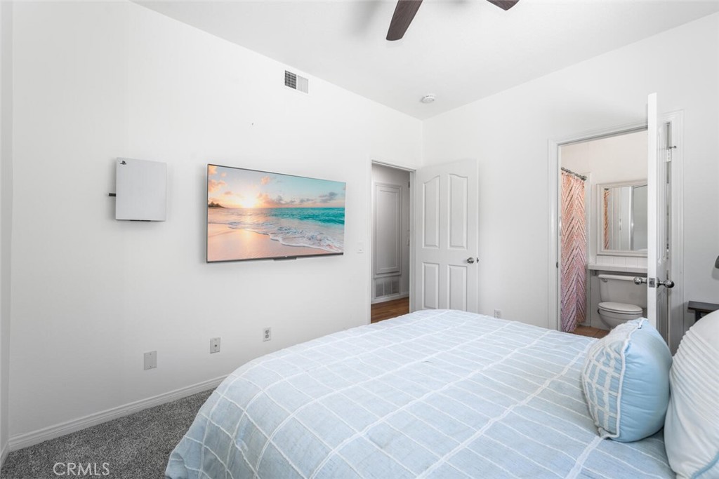1516 Pacific Coast Highway, Unit 101 Huntington Beach, CA 92648 - Photo 30 of 58 a bedroom with a bed and a painting on the wall