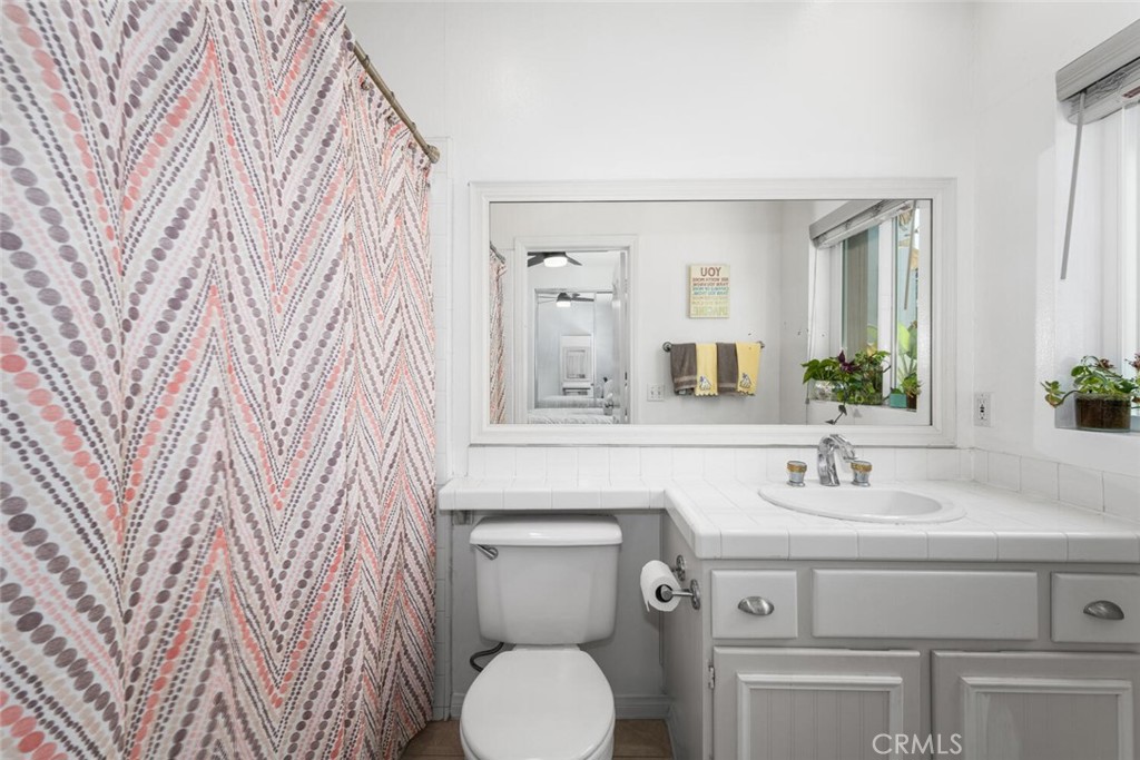 1516 Pacific Coast Highway, Unit 101 Huntington Beach, CA 92648 - Photo 32 of 58 a bathroom with a toilet sink and mirror