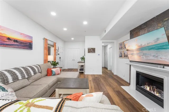 a kitchen with stainless steel appliances a dining table chairs and a refrigerator a sink with wooden floor