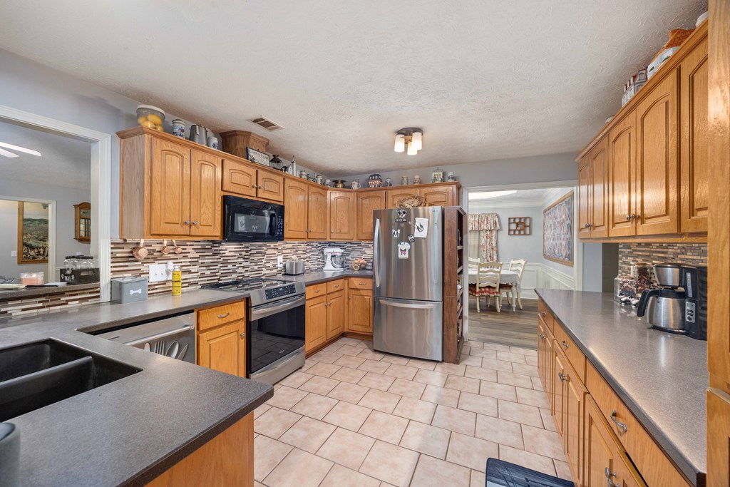 2083 Johnson Mill Road Hamilton, GA 31811 - Photo 9 of 54 a large kitchen with stainless steel appliances kitchen island granite countertop a sink and cabinets