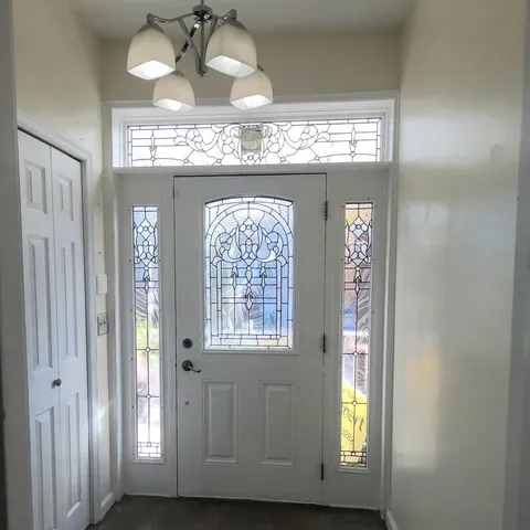 a view of a hallway with windows and chandelier