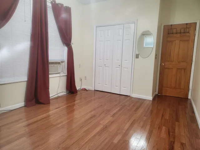 an empty room with wooden floor and closet