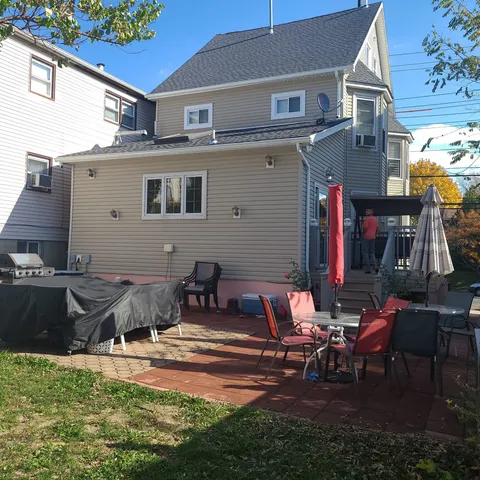 a view of a house with backyard and sitting area
