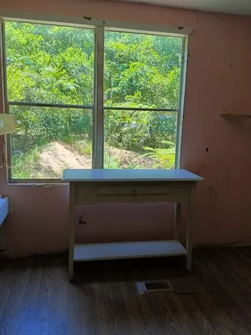 a room with wooden floor and a window