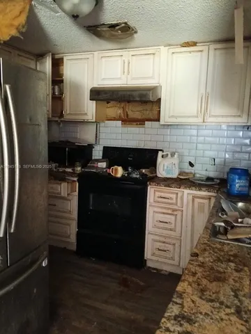 a kitchen with granite countertop a stove and a refrigerator