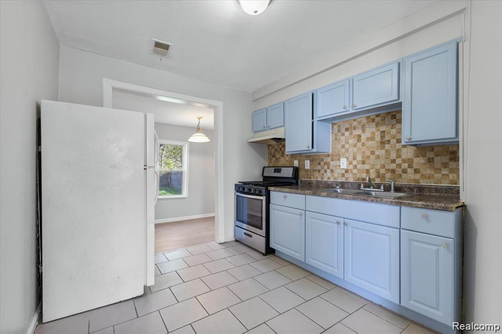 26076 Colgate Street Inkster, MI 48141 - Photo 6 of 24 Kitchen featuring light blue cabinetry, mosaic tile backsplash, and a stainless steel range