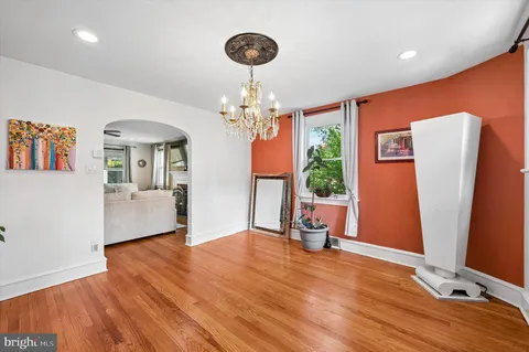 a view of a room with wooden floor and a ceiling fan