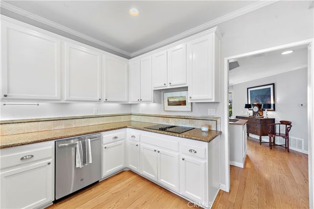 a kitchen with white cabinets and sink
