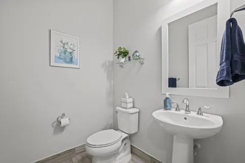 a spacious bathroom with a granite countertop sink a toilet a mirror and shower