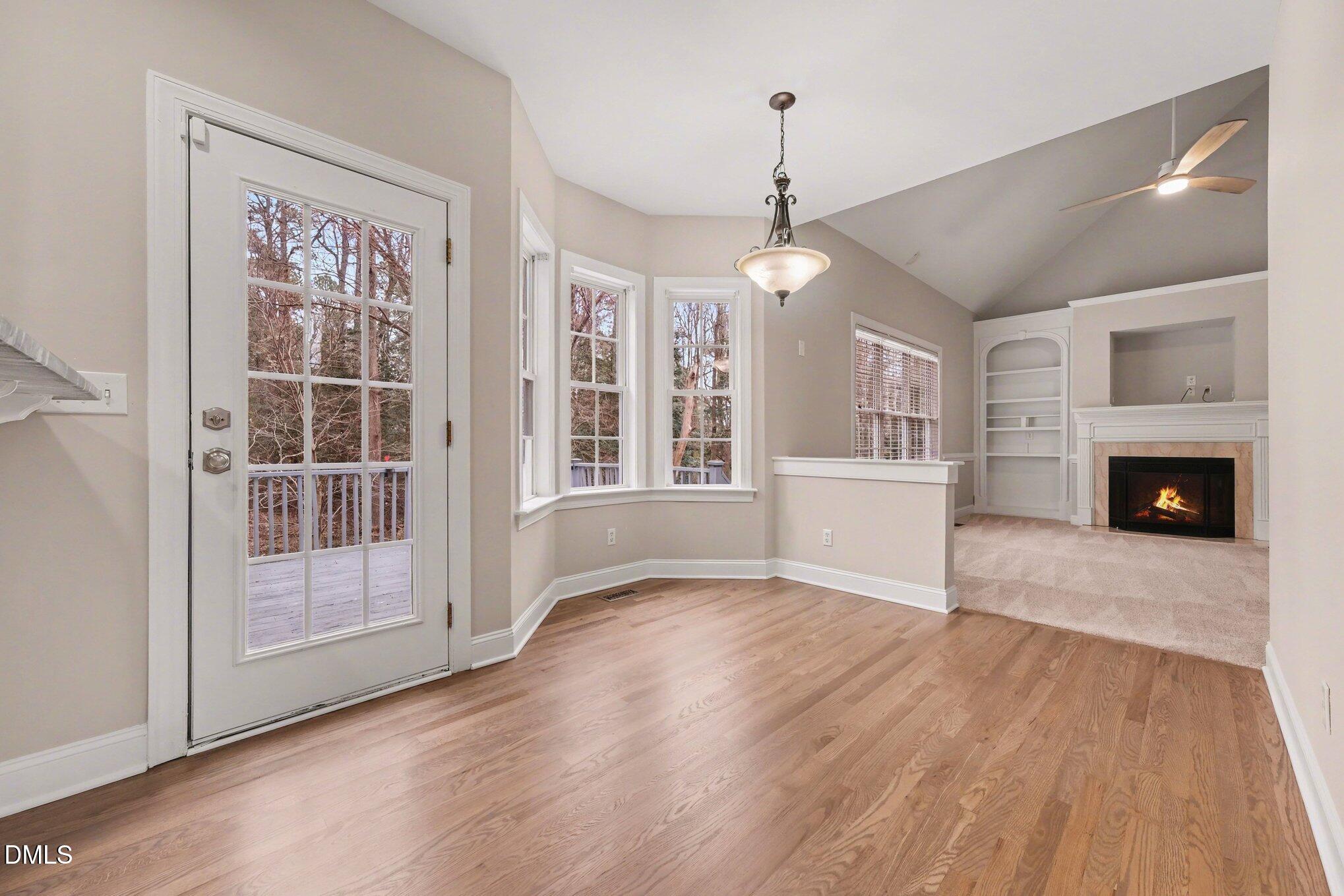 4613 Cherrybark Lane Raleigh, NC 27616 - Photo 8 of 27 an empty room with wooden floor fireplace and windows