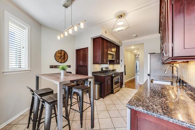 a kitchen with stainless steel appliances kitchen island granite countertop a stove a refrigerator and microwave