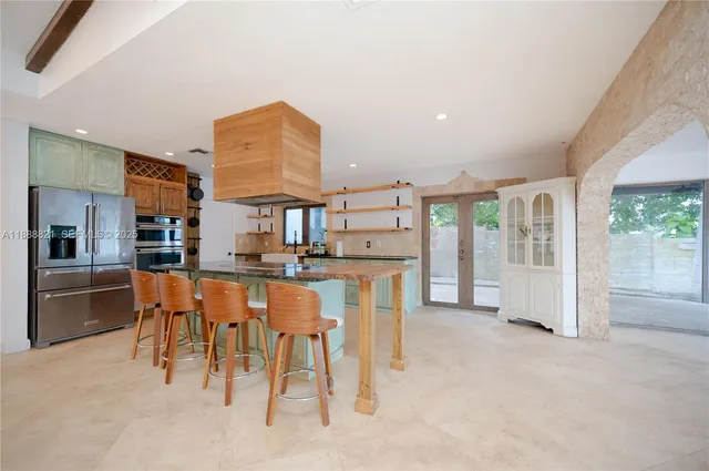 a kitchen with stainless steel appliances kitchen island granite countertop a refrigerator and cabinets