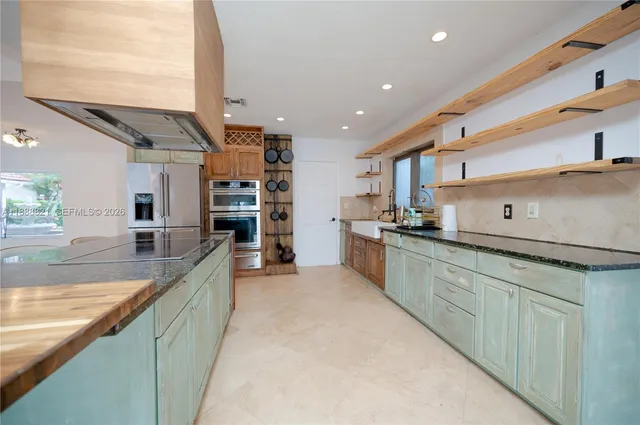 a large kitchen with stainless steel appliances granite countertop a lot of counter space and a sink