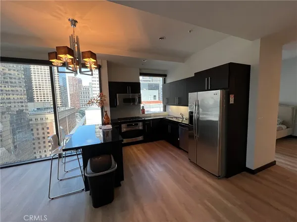 a kitchen with stainless steel appliances wooden floor and refrigerator