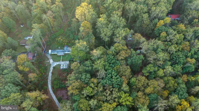 an aerial view of residential house with outdoor space and trees all around
