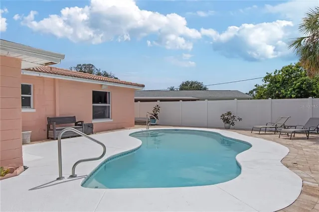 a view of a house with swimming pool and sitting area