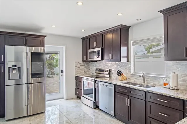 a kitchen with stainless steel appliances granite countertop a refrigerator and a sink