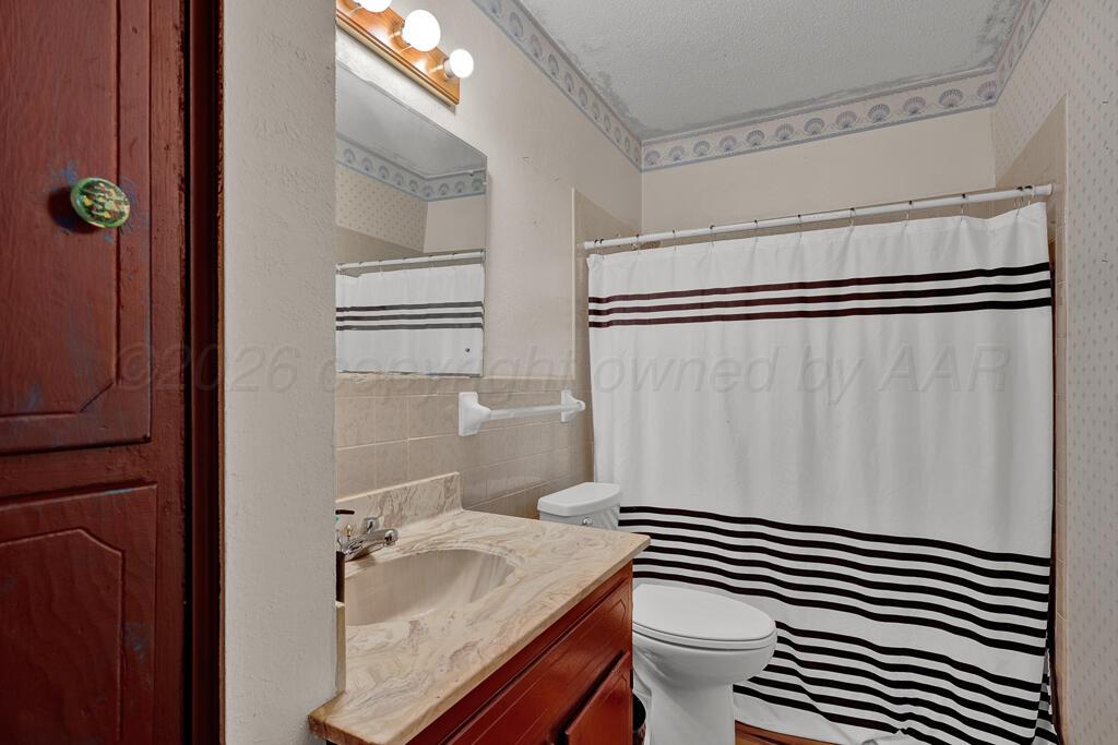 2910 Browning Street Amarillo, TX 79103 - Photo 13 of 28 a bathroom with a sink a toilet and shower