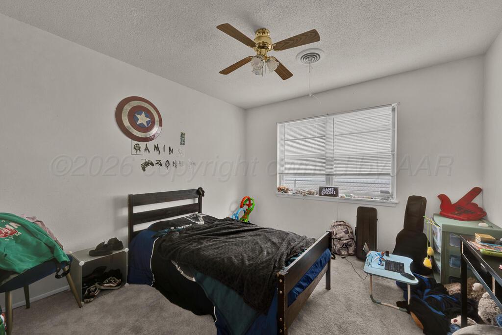 2910 Browning Street Amarillo, TX 79103 - Photo 14 of 28 a bedroom with a bed and a chandelier