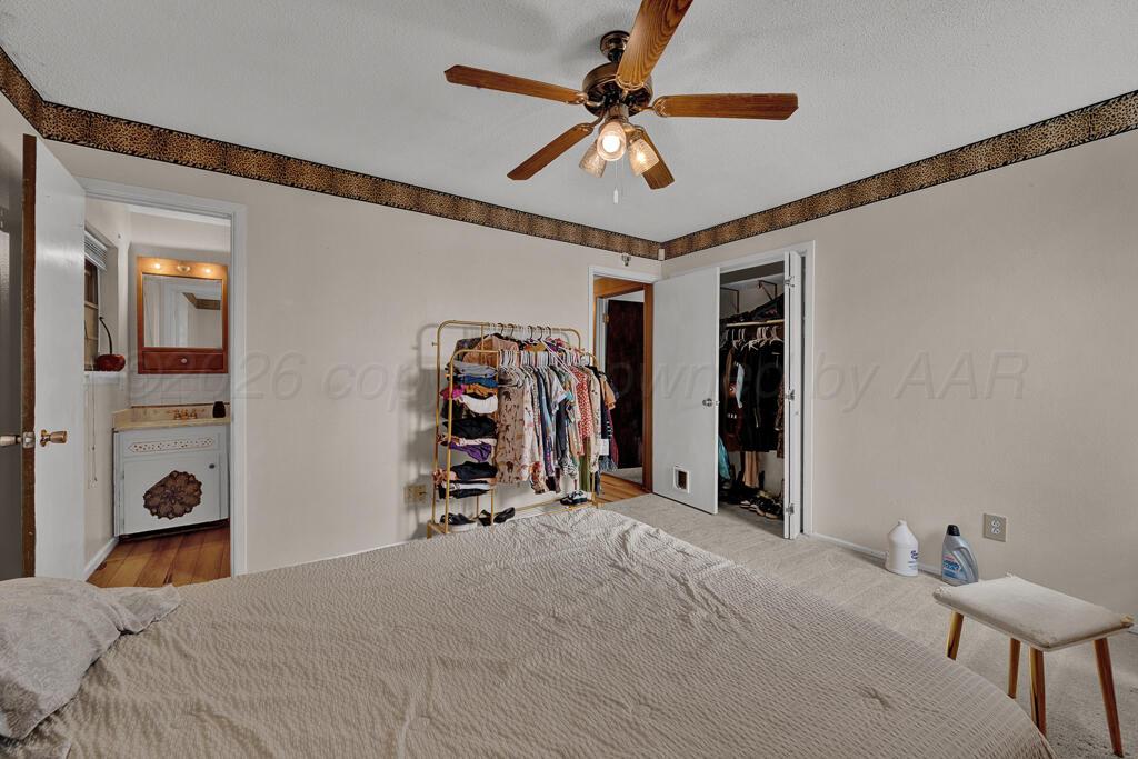 2910 Browning Street Amarillo, TX 79103 - Photo 19 of 28 a bedroom with a bed and a chandelier