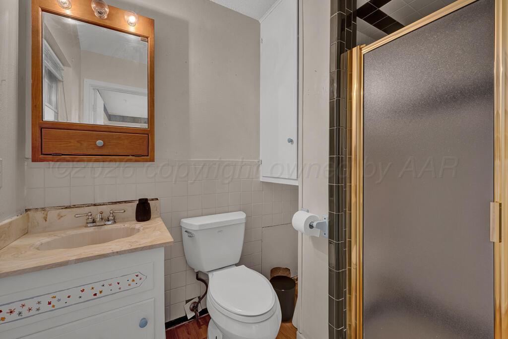 2910 Browning Street Amarillo, TX 79103 - Photo 20 of 28 a white toilet sitting next to a bathroom sink