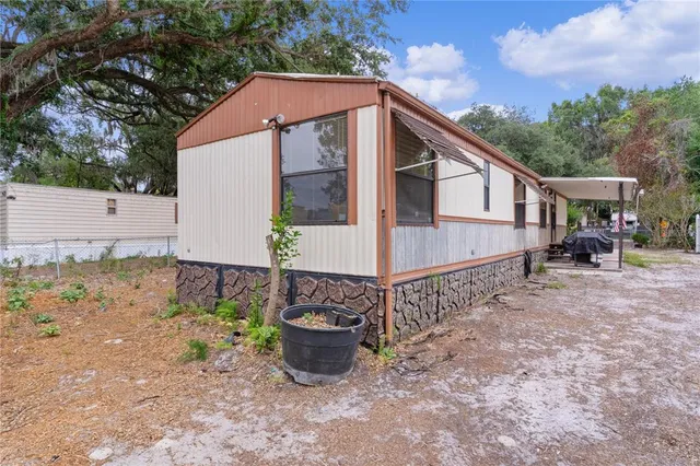 a view of a house with backyard and sitting area