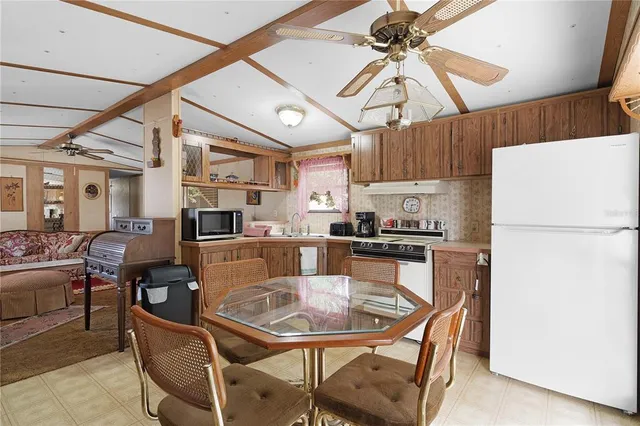 a dining room with stainless steel appliances kitchen island a table and chairs