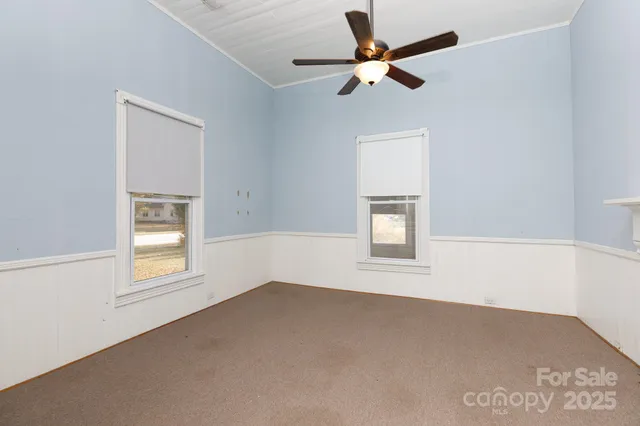 an empty room with a window and a ceiling fan