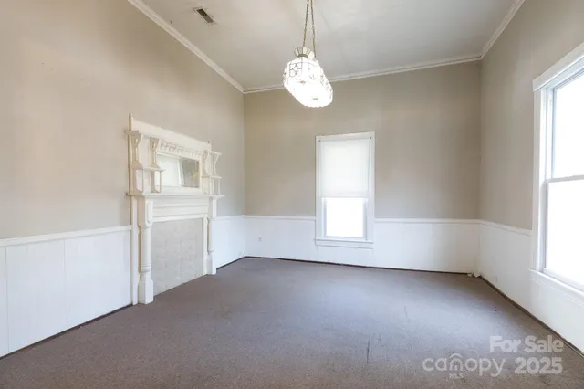 an empty room with windows and chandelier