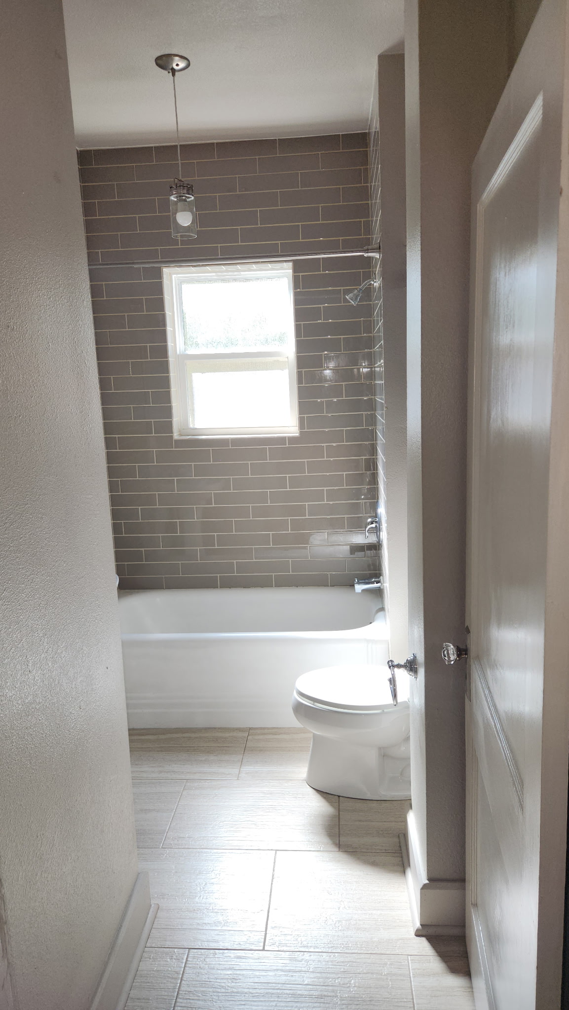 1709 Enfield Road, Unit A Austin, TX 78703 - Photo 5 of 8 A pristine bathroom features a classic bathtub and modern subway tile, offering a clean aesthetic.