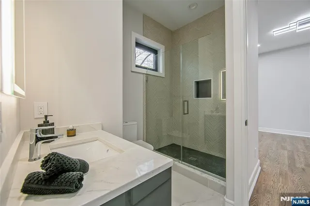 a bathroom with a sink a toilet and shower