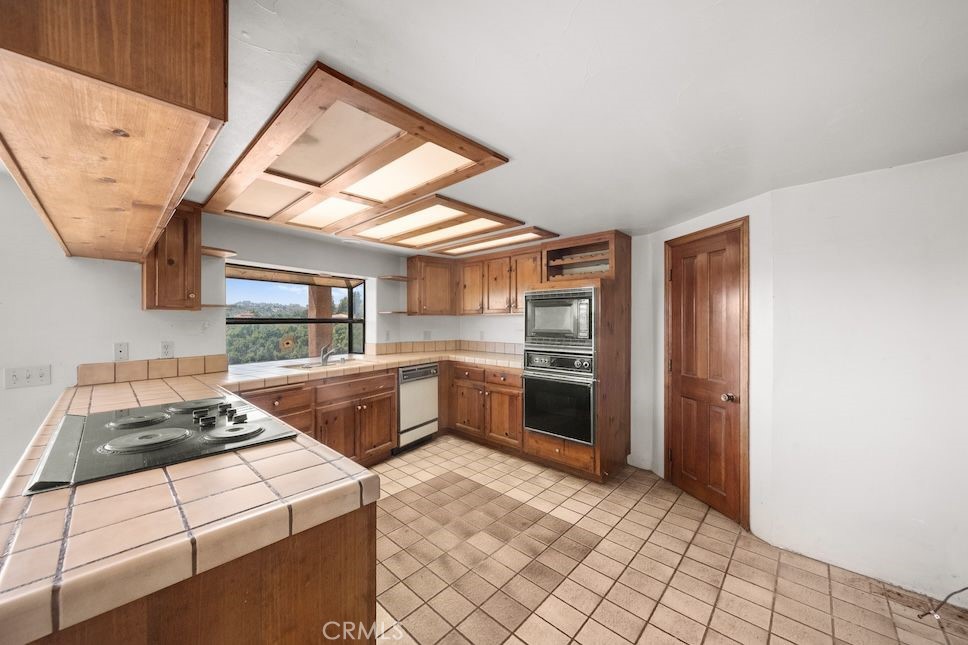 879 Stewart Canyon Road Fallbrook, CA 92028 - Photo 22 of 75 a kitchen with stainless steel appliances a stove a sink and a refrigerator