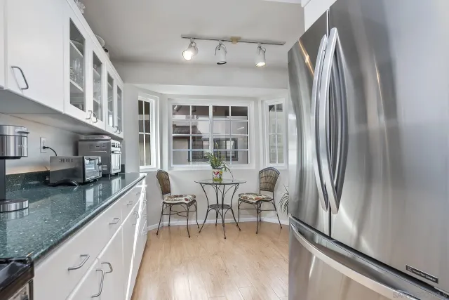 a kitchen with stainless steel appliances granite countertop a refrigerator a stove and a wooden floors