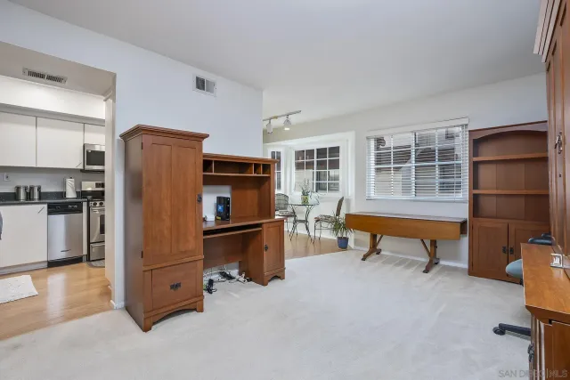 a room with furniture a refrigerator and wooden cabinets