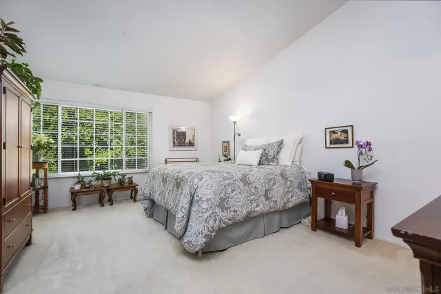 a spacious bedroom with a bed and glass window